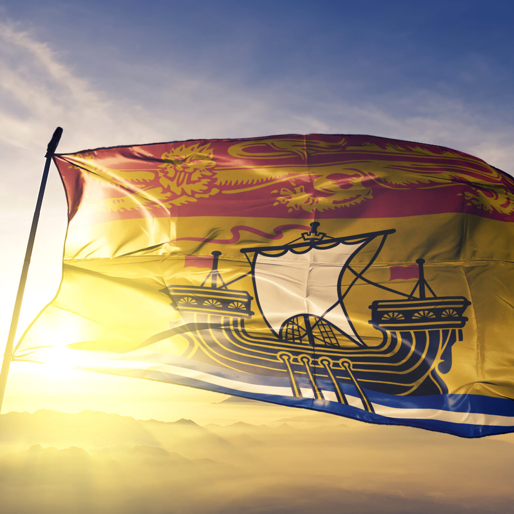 New Brunswick province of Canada flag textile cloth fabric waving on the top sunrise mist fog
