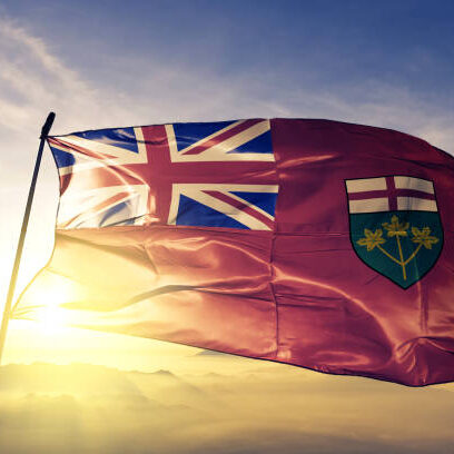 Ontario province of Canada flag on flagpole textile cloth fabric waving on the top sunrise mist fog